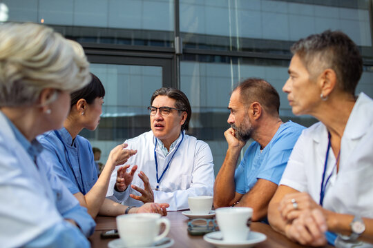 Doctors and nurses meeting outdoors over coffee