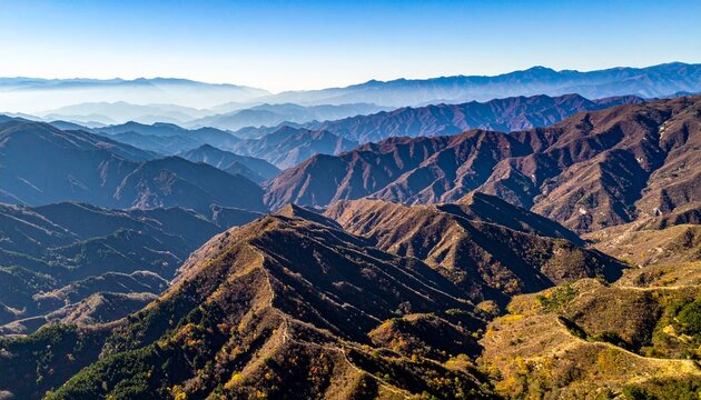 Layered mountain ranges stretching into the distance beneath a clear blue sky