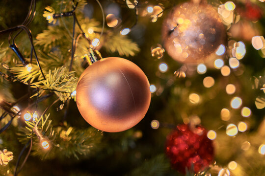 Copper Christmas Bauble Hanging Among Warm Festive Lights