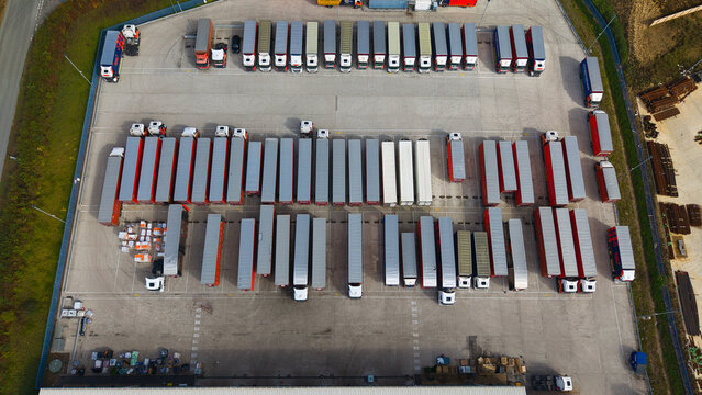 Aerial view of a logistics warehouse yard filled with numerous parked semi-truck trailers and HGVs in Bury St Edmunds, England, United Kingdom.
