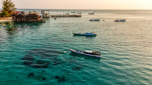 Aerial view of Fishing Boat at Derawan Island with turquoise waters, coral reefs, and white sandy beaches in Berau, East Kalimantan, Indonesia.