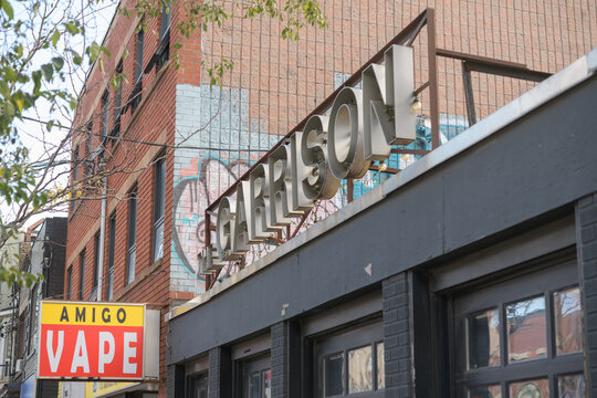 projecting sign of Amigo Convenience & Vape located at 1193 Dundas St W and open channel lettering sign on the front of The Garrison, a live music venue, 1197 Dundas W, Toronto