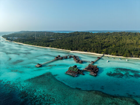 Aerial view of Maratua Island featuring turquoise waters, coral reefs, and white sandy beaches in Berau, East Kalimantan, Indonesia.