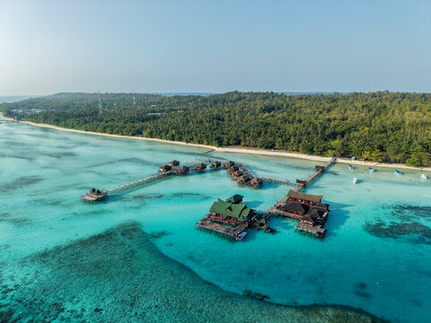 Aerial view of Maratua Island featuring turquoise waters, coral reefs, and white sandy beaches in Berau, East Kalimantan, Indonesia.
