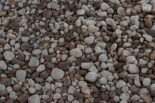 River pebble stones texture background top view full frame pattern. Smooth round gravel rock stones background for landscaping and garden design