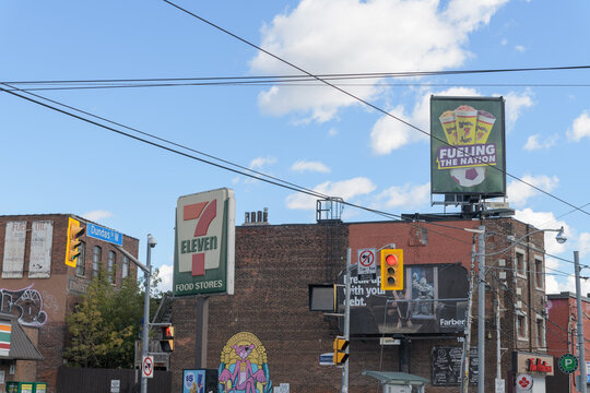 7-Eleven sign at 1260 Dundas St W at Dovercourt Rd with other businesses and a Tim Hortons coffee shop in Toronto