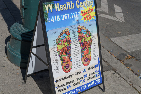 outdoor, A-frame sandwich board featuring poster of YY Health Centre, a spa, located at 294 Spadina Av, Toronto