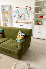 Interior design and home decor, modern living room with green velvet sofa and bicycle wall art in a bright apartment with minimalist furniture © Pixel-Shot
