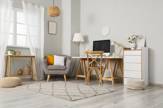 Remote work and home office setup, modern workspace with computer desk and comfortable armchair in a bright living room interior for freelance lifestyle