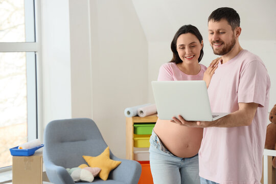 Family planning and home renovation, pregnant woman and husband using laptop to choose nursery decor in new house during pregnancy and lifestyle