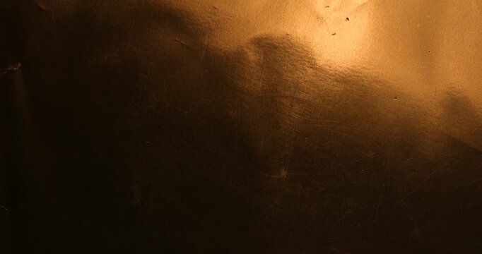 Dark golden scratched metallic texture abstract background closeup