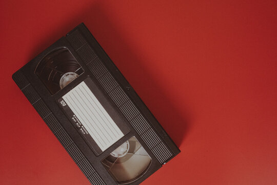 Single VHS videotape diagonally arranged on red background