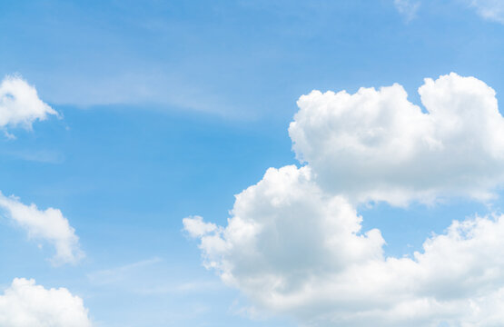 Beautiful blue sky with fluffy white cumulus clouds on a sunny day, creating a peaceful natural cloudscape background with generous copy space for weather, summer, climate and environmental themes