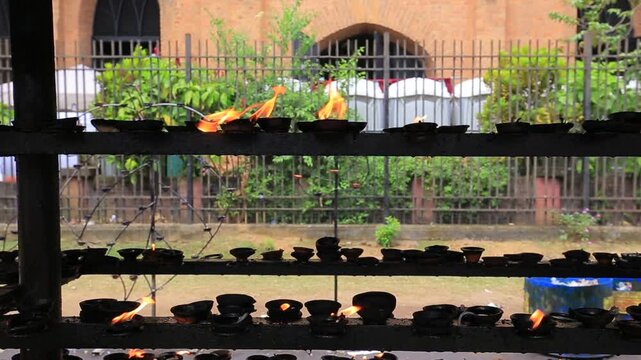 Traditional clay oil lamps burning at buddhist temple