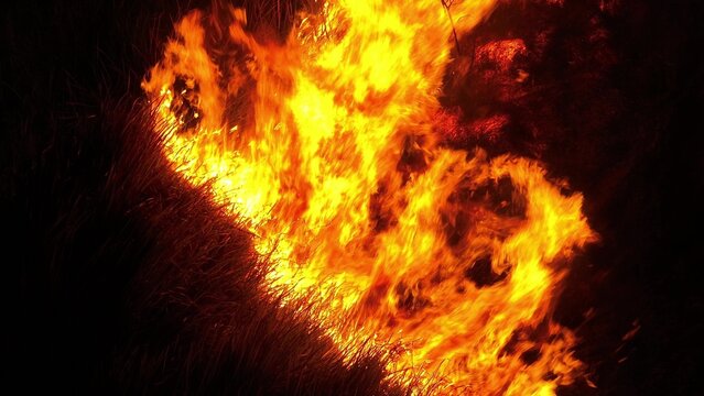 Drone view of severe wildfire at night symbolizes climate crisis pressures, hotter and drier conditions, uncontrolled fire spread, and urgent concerns over increasing wildfire disasters. Thailand. 4k.