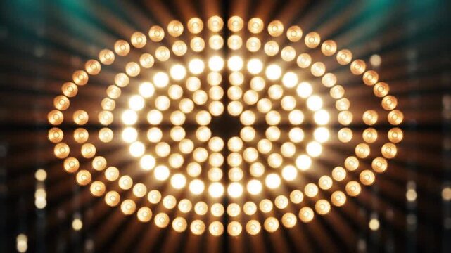 Bright glowing light bulbs arranged in an oval pattern illuminating a dark studio stage environment