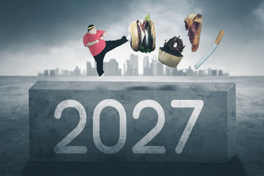 Overweight Man Kicking Away Junk Food and Cigarette on Block with 2027 Number