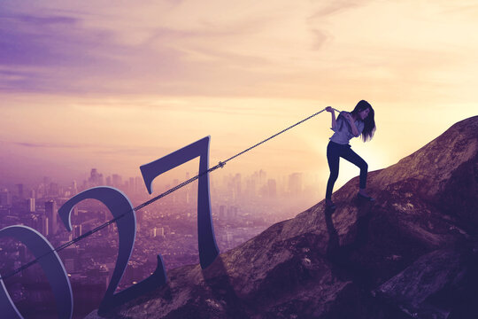 Businesswoman Pulling Giant 2027 Year Numbers Up a Mountain Peak