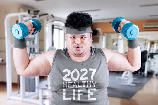 Overweight Man Lifting Dumbbells in Gym 2027 Healthy Life Concept