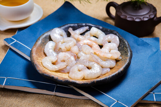 Raw peeled shrimps served on white ceramic plate