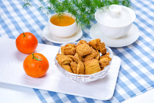 Traditional crispy cookies with teacup on checkered tablecloth
