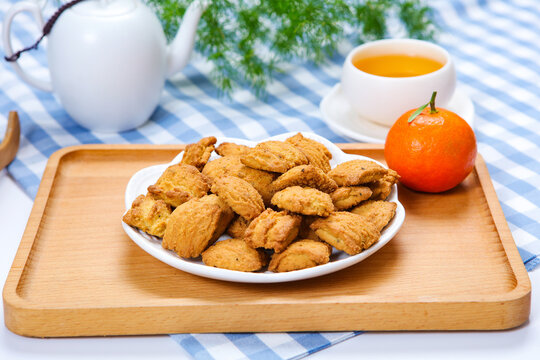 Traditional crispy cookies with teacup on checkered tablecloth