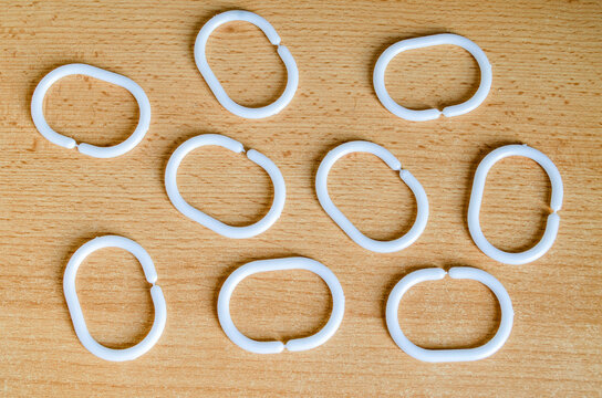 White plastic rings arranged on a wooden surface in a random pattern