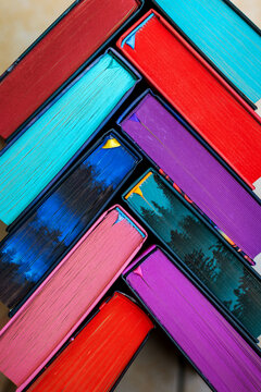 Close up of colorful book page edges arranged diagonally in a vibrant abstract geometric pattern, bright rainbow colors creating a creative background for education and reading.