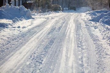Fototapeta premium Snow covers a quiet road with tire tracks