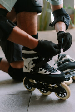 Person preparing for inline skating by lacing rollerblades