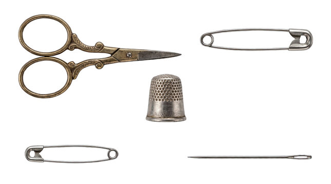 Antique sewing notions including scissors thimble safety pins and needle arranged on a clean surface Isolated on transparent background