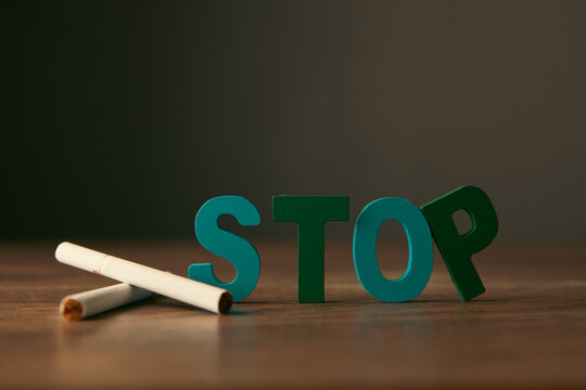 Stop smoking concept. Cigarette and stop sign on wooden table.
