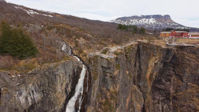 FPV drone flies above the gorge at Voringfossen and heads toward the valley, revealing steep canyon walls and a wider view of the Norwegian landscape.