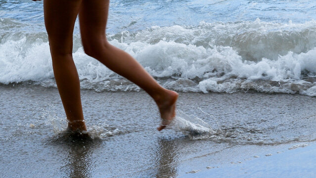 Woman walking barefoot summer beach. Relaxation Travel woman foot walking tropical summer beach. Close up legs walk along wave of sea water sand beach. Enjoy freedom barefoot leg walk outdoor