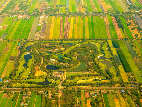 Aerial view Crop Green dry patterns farm landscape background. Land landscape vibrant agricultural fields window airplane sky summer tropical summertime on light sunny day cloudscape countryside