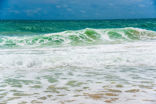 Tropical sea beach in summer seaside outdoor. Turquoise ocean sea water. Blue sea marine ocean seascape tropical huge wave on blurred background. Seascape dark ocean background wave splash on rock