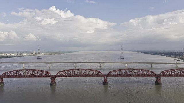 Aerial view of bridges spanning a vast river under a cloudy sky