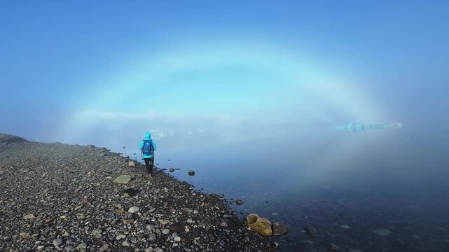 Woman admiring a fogbow over J&ouml;kuls&aacute;rl&oacute;n glacier lagoon, Iceland