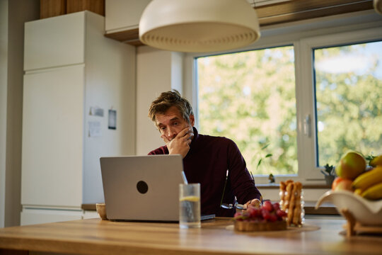 Man experiencing stress while remote working on laptop
