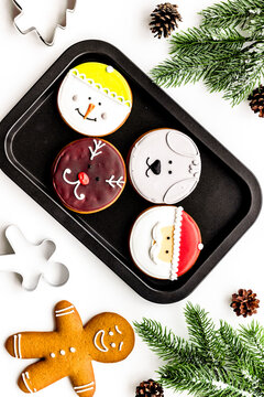 New Year Eve's recipes. Gingerbread cookies with confictionery glaze near spruce branch on white background top view