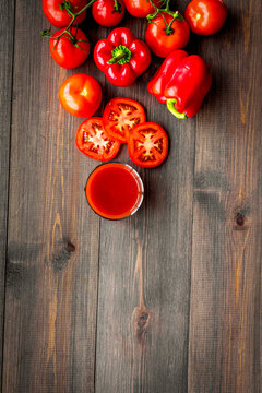 Red detox beverage with paprika and tomatoes on dark wooden background top view copyspace