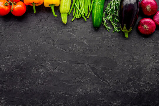 Colorful vegetables for healthy diet. Paprika, tomatoes, carrot, zucchini, eggplant on balck background top view copyspace