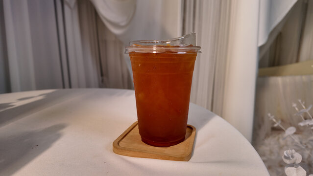 Refreshing iced drink served in clear cup on wooden coaster