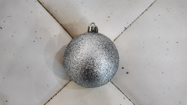 Shiny Silver Christmas Ornament on a Light Marble Background