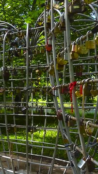 Numerous love padlocks hanging on a heart shaped metal sculpture in Keila, Estonia. This romantic symbol represents the unbreakable bond and commitment of newlyweds and couples