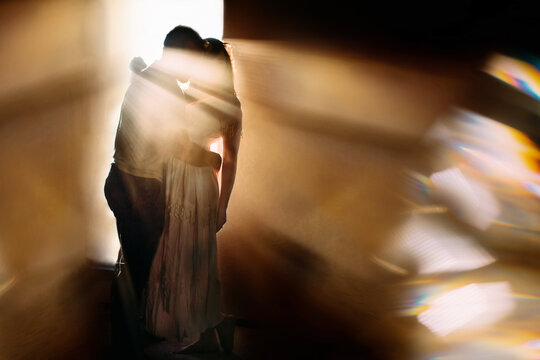 A couple embracing in silhouette with dramatic light rays