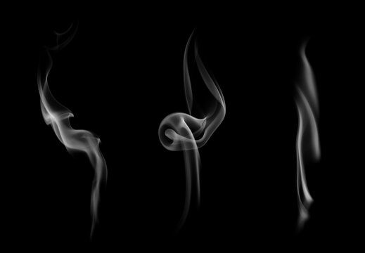 Set of three curly white incense smoke wisps rising gracefully on a black background. Concept of spiritual atmosphere, aromatherapy, mindfulness meditation, and abstract vapor overlay.