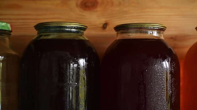 An empty jar gives way to jars of homemade juices and compotes as the camera moves along a shelf.