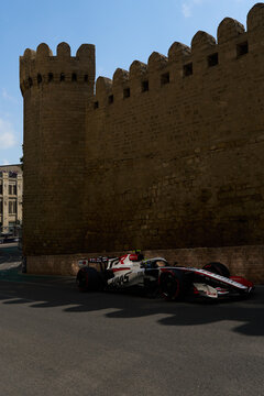 BAKU, AZERBAIJAN - SEPTEMBER 2026: MoneyGram Haas F1 Team race car turns through the narrow Old City castle section during the Azerbaijan Grand Prix