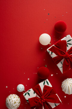 Festive Christmas gifts with red velvet bows and ornaments for Merry Christmas and Happy New Year celebration on festive vertical red copyspace
